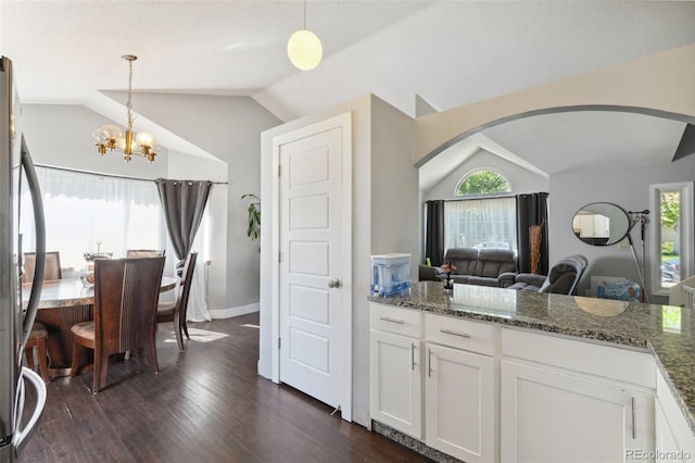 21111 E 43rd Ave, Denver, CO 80249 - kitchen with lofted ceiling, stainless steel fridge, a chandelier, arched walkways, and white cabinets
