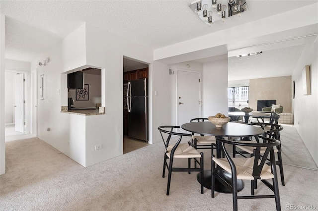 carpeted dining space with a textured ceiling