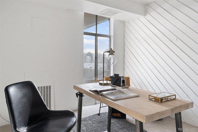 carpeted office featuring wood walls