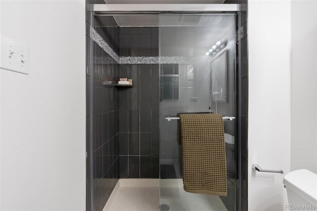 bathroom with an enclosed shower and toilet