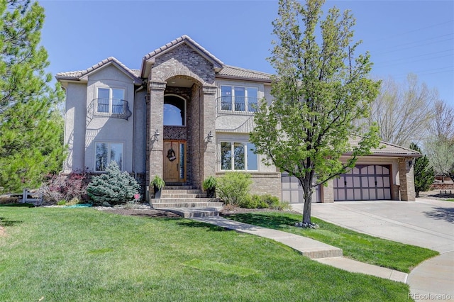 traditional-style home with stucco siding, a tile roof, a front lawn, a balcony, and driveway
