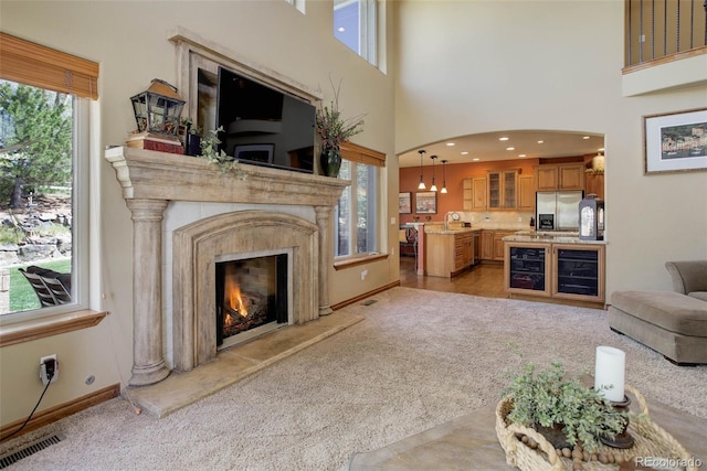 living room with light carpet, baseboards, a fireplace, and a healthy amount of sunlight
