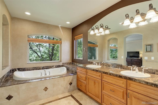 bathroom with a sink, double vanity, a garden tub, and tile patterned flooring