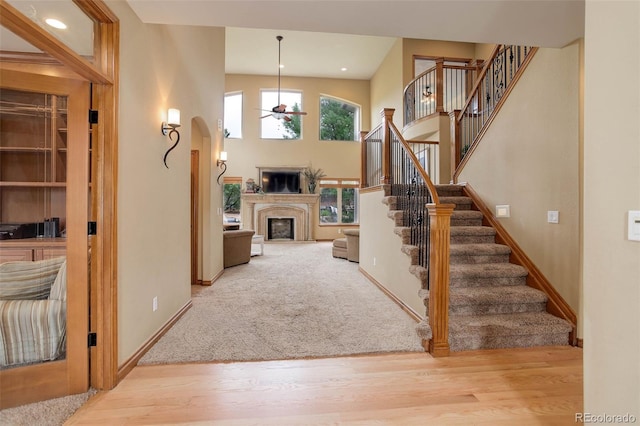 12825 W 81st Ave, Arvada, CO 80005 - entryway with a fireplace, wood finished floors, ceiling fan, baseboards, and stairs