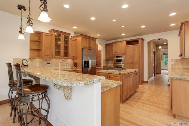 12825 W 81st Ave, Arvada, CO 80005 - kitchen featuring appliances with stainless steel finishes, open shelves, arched walkways, a peninsula, and recessed lighting