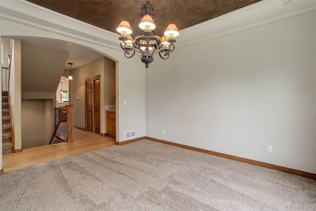 12825 W 81st Ave, Arvada, CO 80005 - unfurnished room with light carpet, arched walkways, a chandelier, baseboards, and stairway