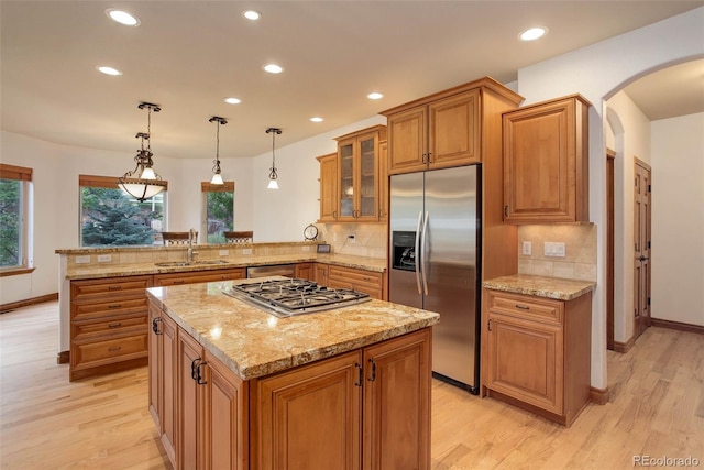 12825 W 81st Ave, Arvada, CO 80005 - kitchen with appliances with stainless steel finishes, arched walkways, brown cabinetry, a peninsula, and recessed lighting