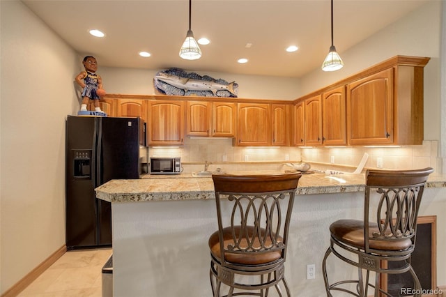 12825 W 81st Ave, Arvada, CO 80005 - kitchen with black fridge with ice dispenser, stainless steel microwave, tasteful backsplash, light countertops, and recessed lighting