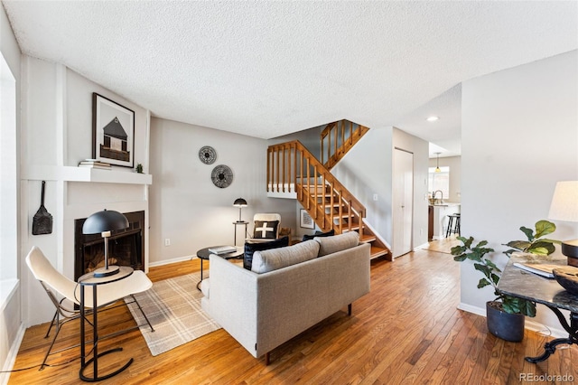 living room with wood-type flooring and a textured ceiling