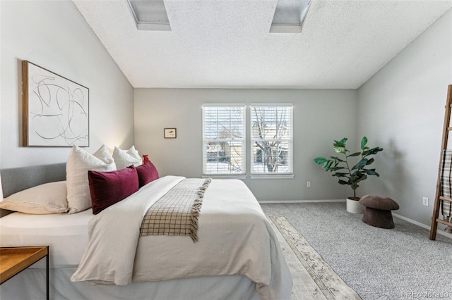 bedroom with carpet, attic access, baseboards, and a textured ceiling