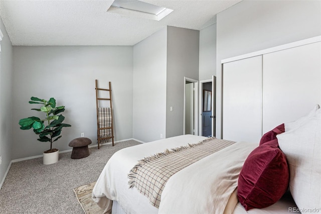 bedroom with a closet, carpet flooring, a textured ceiling, and baseboards