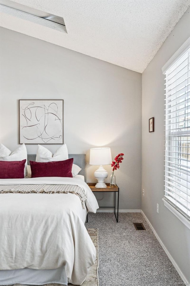 bedroom featuring a textured ceiling, carpet flooring, and baseboards