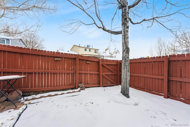 snowy yard with fence and a gate