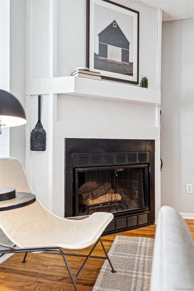 room details with a textured ceiling, a fireplace, and wood finished floors