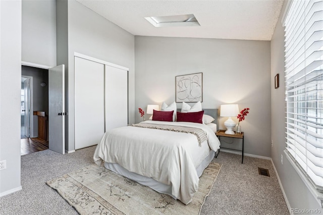 bedroom featuring light colored carpet, baseboards, vaulted ceiling, a closet, and attic access