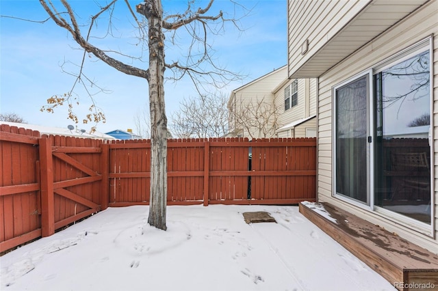 snow covered patio with entry steps, a gate, and fence