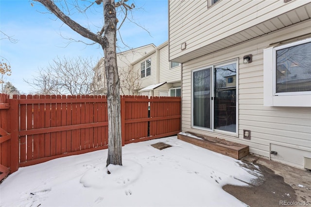 snow covered patio featuring entry steps and fence