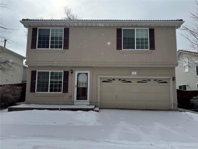 traditional home with an attached garage and stucco siding