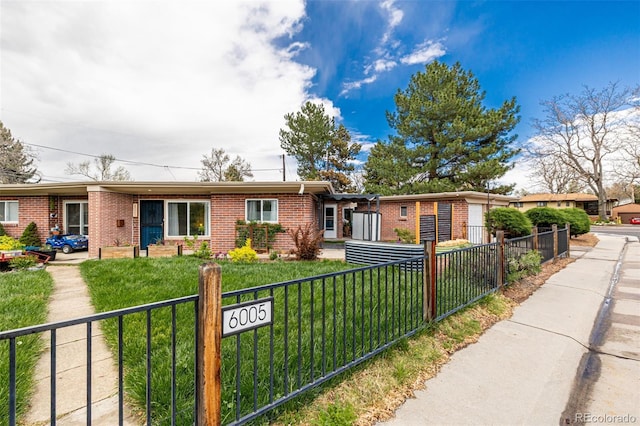 6005 W 39th Ave Unit 6005, Wheat Ridge, CO 80033 - ranch-style home featuring a fenced front yard, brick siding, and a front lawn