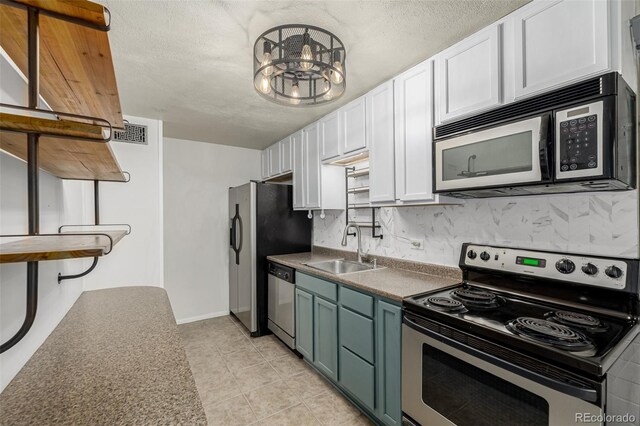 6005 W 39th Ave Unit 6005, Wheat Ridge, CO 80033 - kitchen with a sink, an inviting chandelier, white cabinetry, backsplash, and appliances with stainless steel finishes
