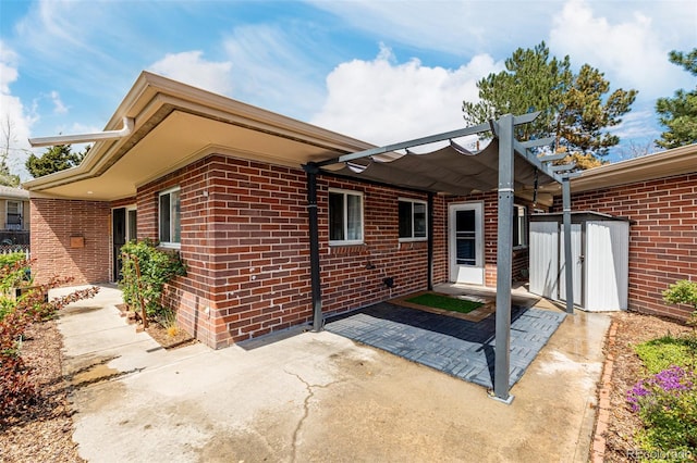6005 W 39th Ave Unit 6005, Wheat Ridge, CO 80033 - exterior space with brick siding, an outdoor structure, a patio, and a storage unit