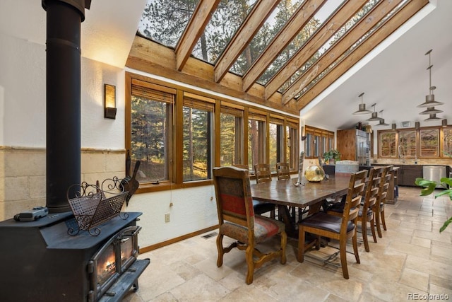 82 Lenawee Ln, Dillon, CO 80435 - dining room with a wood stove, stone tile floors, high vaulted ceiling, and baseboards