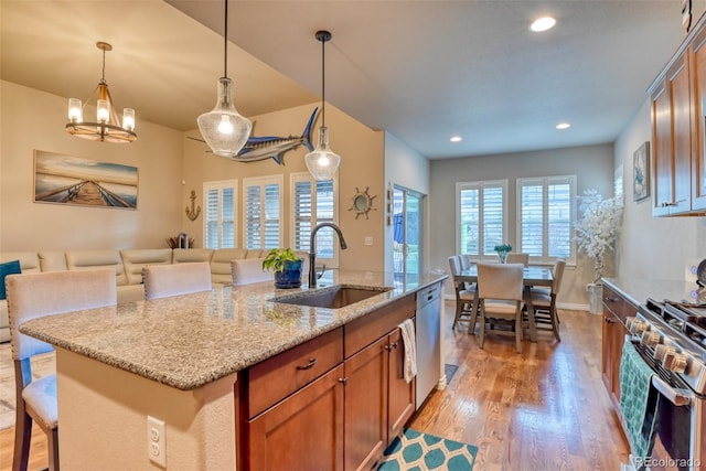 4544 Portillo Pl, Colorado Springs, CO 80924 - kitchen with light wood finished floors, stainless steel appliances, a sink, and light stone counters