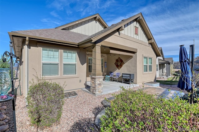 4544 Portillo Pl, Colorado Springs, CO 80924 - view of front of home with board and batten siding, a patio area, a shingled roof, and stucco siding