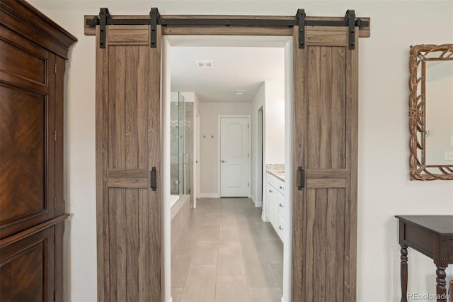 interior space with a barn door and light tile patterned floors