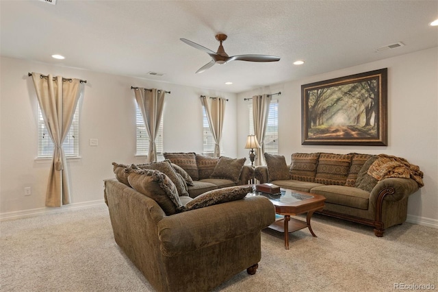 carpeted living room featuring ceiling fan and a wealth of natural light