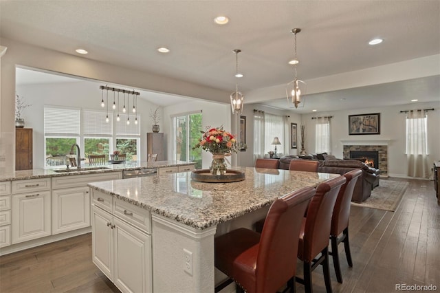 kitchen featuring a fireplace, a healthy amount of sunlight, dark hardwood / wood-style flooring, and sink