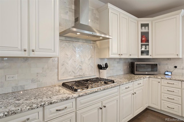 kitchen with decorative backsplash, dark wood-type flooring, appliances with stainless steel finishes, and wall chimney exhaust hood