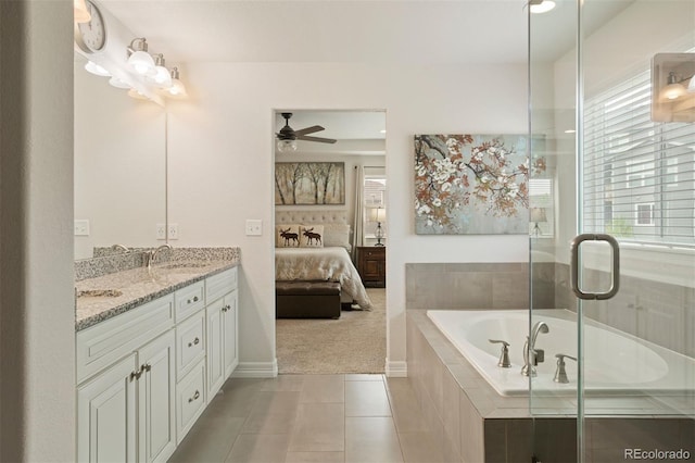 bathroom with tiled bath, vanity, ceiling fan, and tile patterned floors