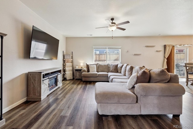 living room featuring dark wood-style floors, visible vents, ceiling fan, a textured ceiling, and baseboards