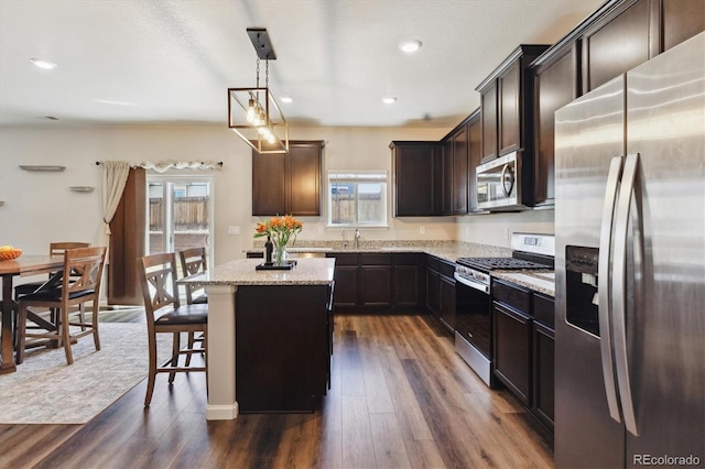 kitchen with light stone countertops, plenty of natural light, appliances with stainless steel finishes, and a center island