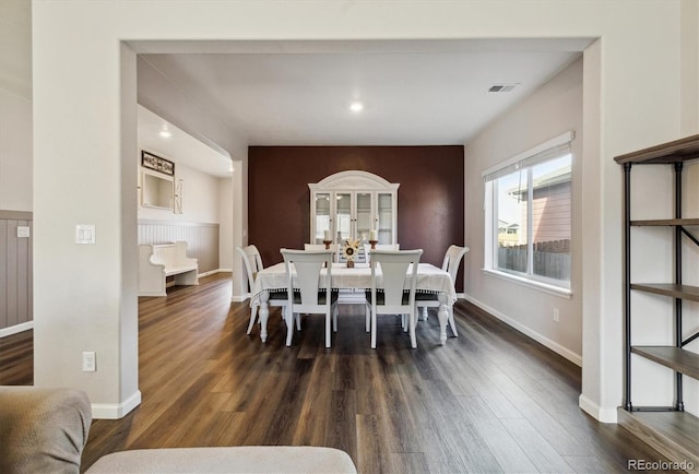 dining space featuring dark wood-style floors, visible vents, and baseboards