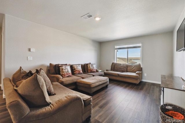 living room featuring baseboards, visible vents, dark wood finished floors, and a textured ceiling