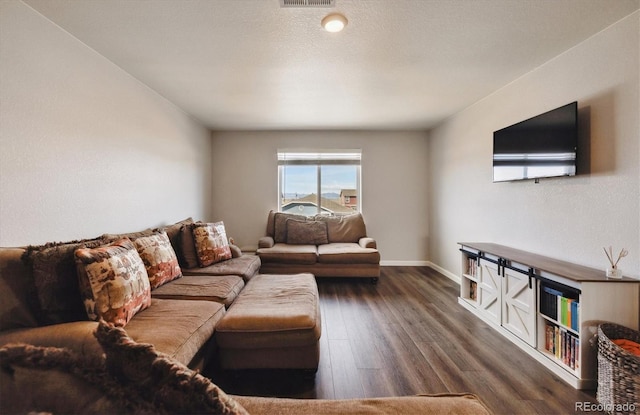 living area with dark wood-style floors, baseboards, and visible vents