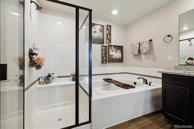 full bath with vanity, wood finished floors, a shower stall, and a bath