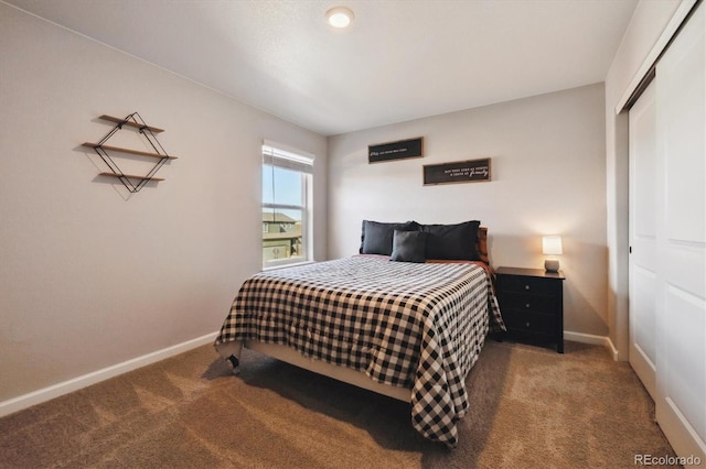 carpeted bedroom with baseboards and a closet