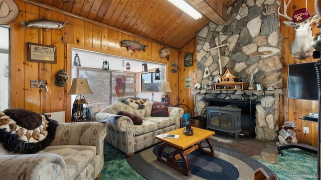 living room with vaulted ceiling, a wood stove, wooden walls, and wood ceiling