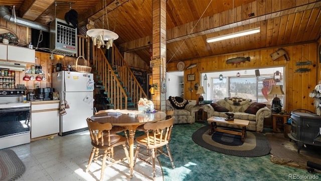 dining area featuring vaulted ceiling, wood walls, and wood ceiling