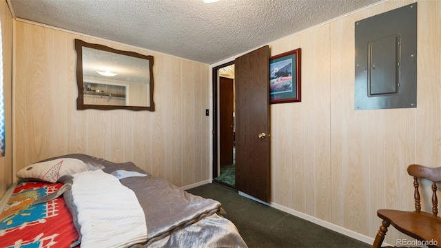 bedroom featuring wooden walls, dark carpet, a textured ceiling, and electric panel