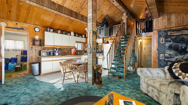 kitchen with white cabinets, vaulted ceiling with beams, light colored carpet, and wooden ceiling