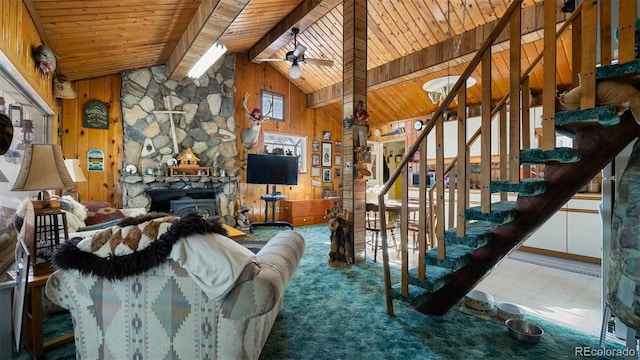 unfurnished living room with beam ceiling, ceiling fan, wood walls, a fireplace, and wood ceiling