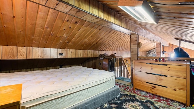 bedroom with vaulted ceiling, wooden ceiling, and wood walls