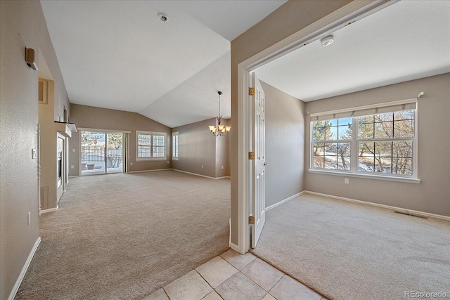 unfurnished living room with lofted ceiling, light colored carpet, and a chandelier