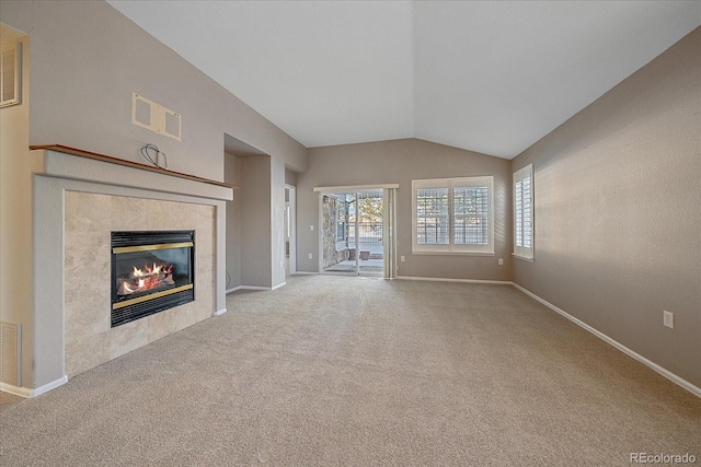 unfurnished living room with light colored carpet, vaulted ceiling, and a tile fireplace