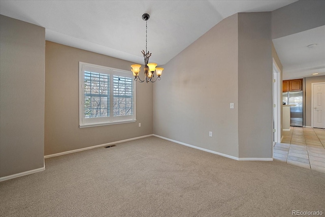 carpeted empty room featuring a notable chandelier and vaulted ceiling