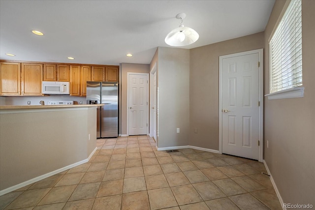 kitchen with light tile patterned floors and stainless steel refrigerator with ice dispenser